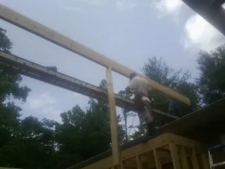 Carpenter setting a ridge beam over a new addition frame — Ice Dam Removal by Roofing Brothers in Pacific Palisades