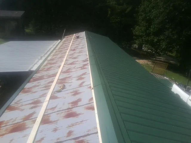 Old rusted panels beside newly installed green metal roofing — Wind Damage Roof Repair by Roofing Brothers in Pacific Palisades