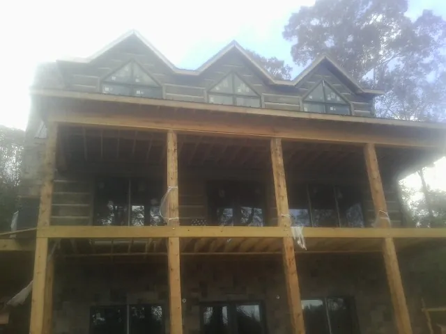 Dormers and porch framing on a large log home under construction — Roof Coating work by our crew in Pacific Palisades