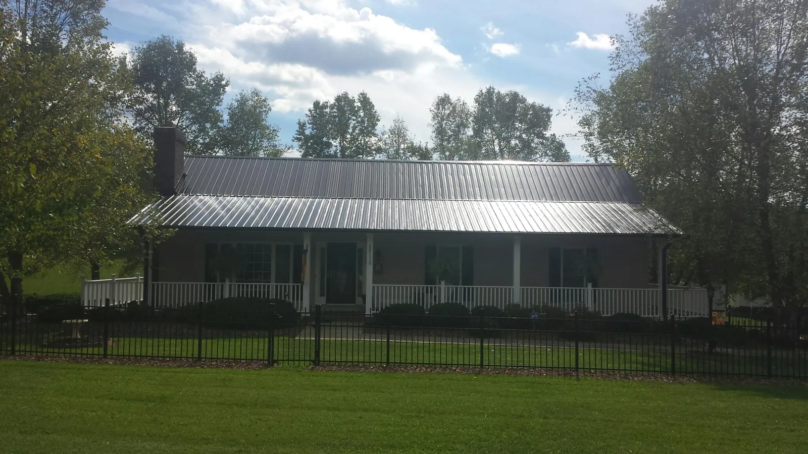 Gray metal roof on a brick ranch with a full width front porch — Gutter Guard Installation work by our crew in Pacific Palisades