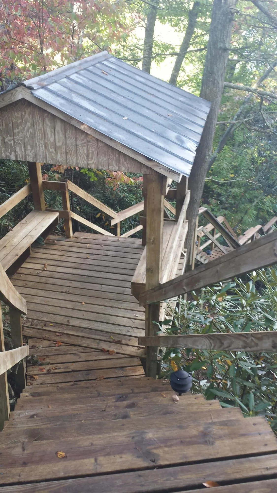 Metal roofed shelter over wooden steps on a wooded walkway in Pacific Palisades